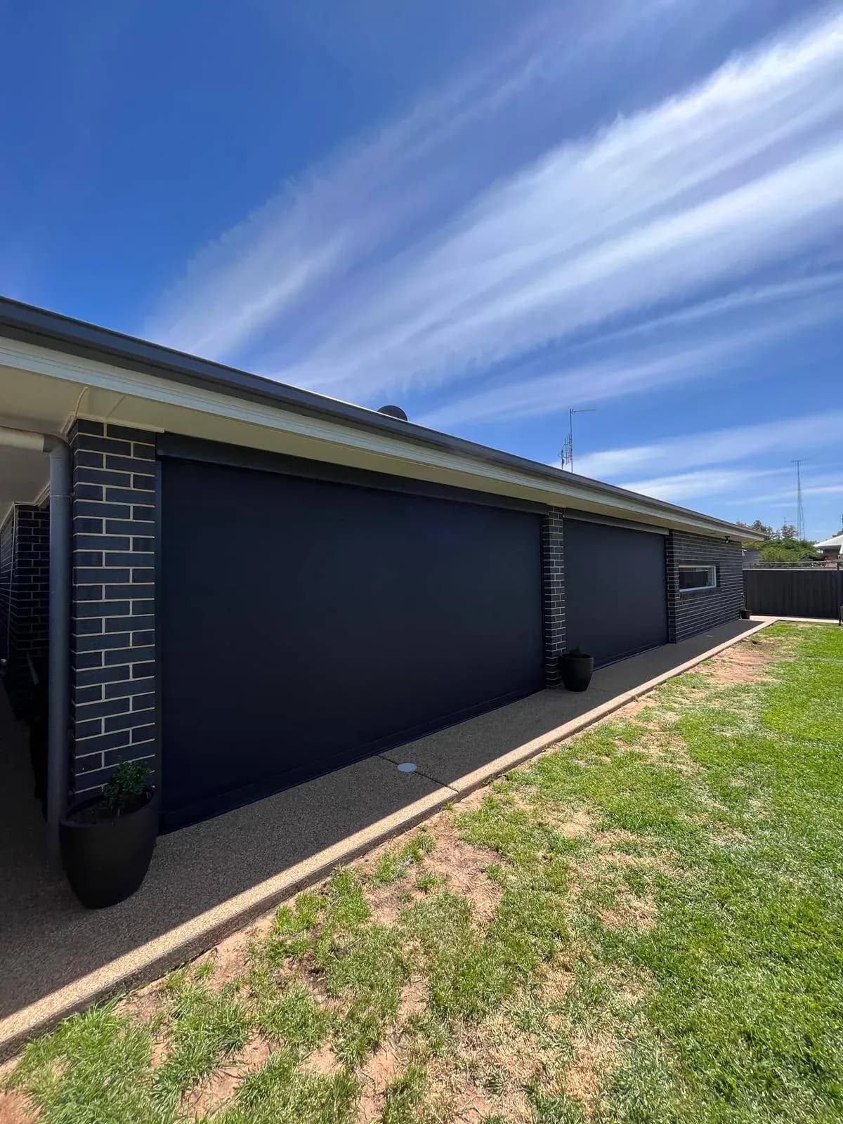 Large format zipscreens on brick home exterior