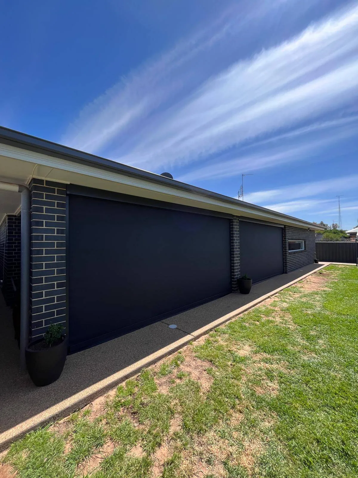 Large format zipscreens on brick home exterior