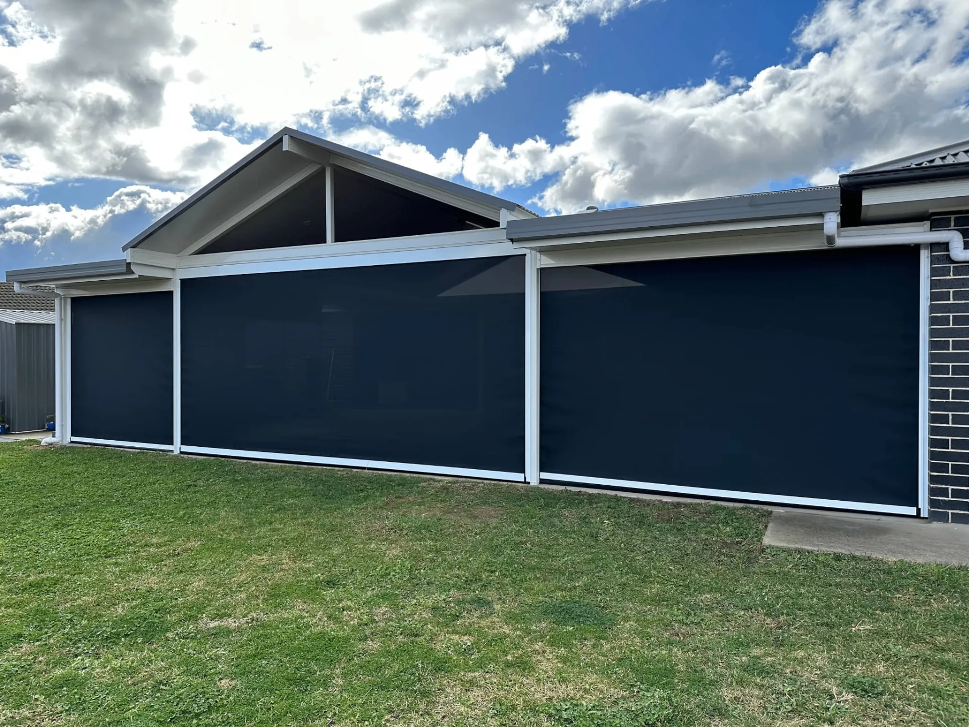 Wide span zipscreens on modern white patio structure