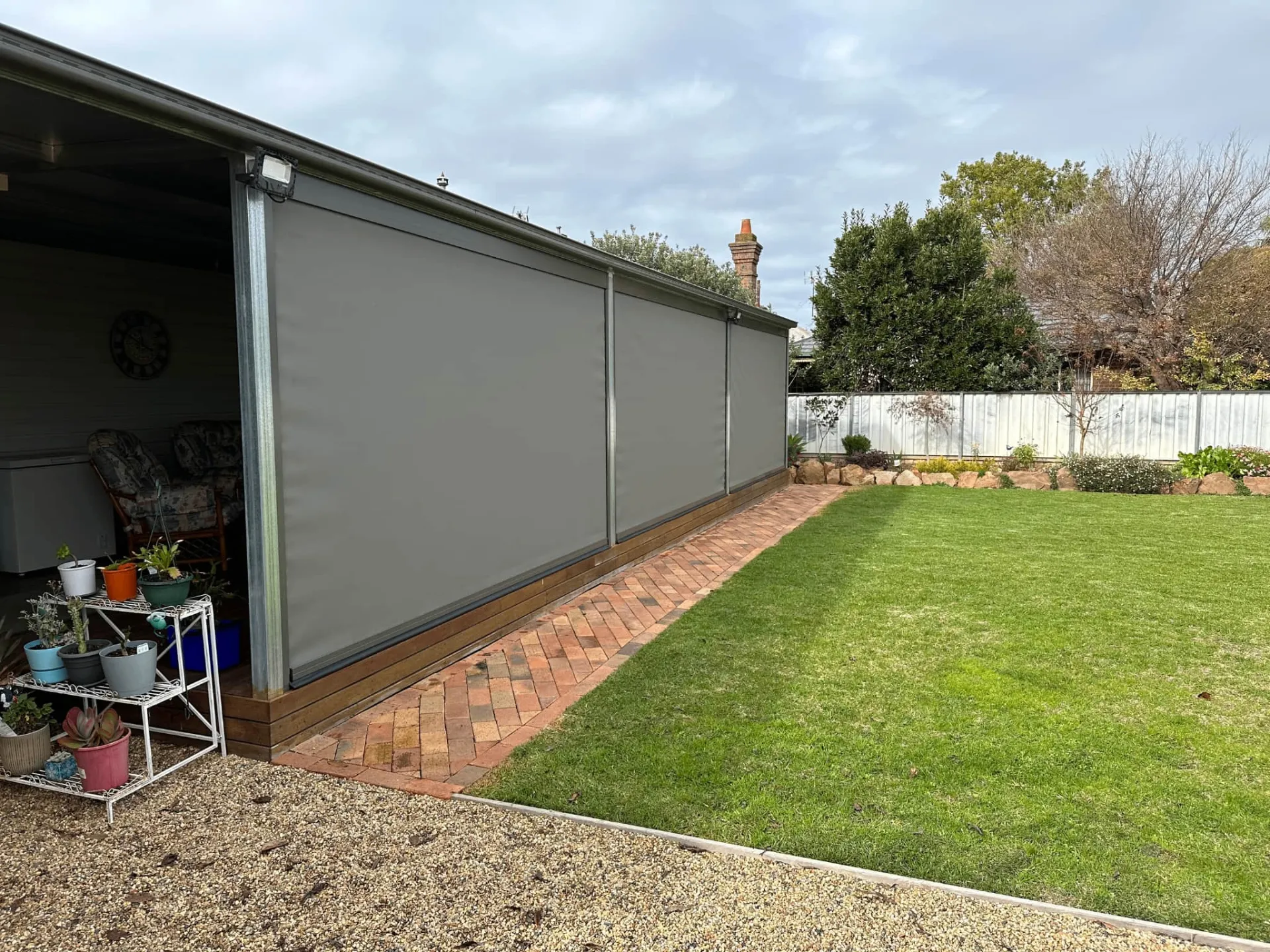 Side view of long patio enclosure with grey blinds