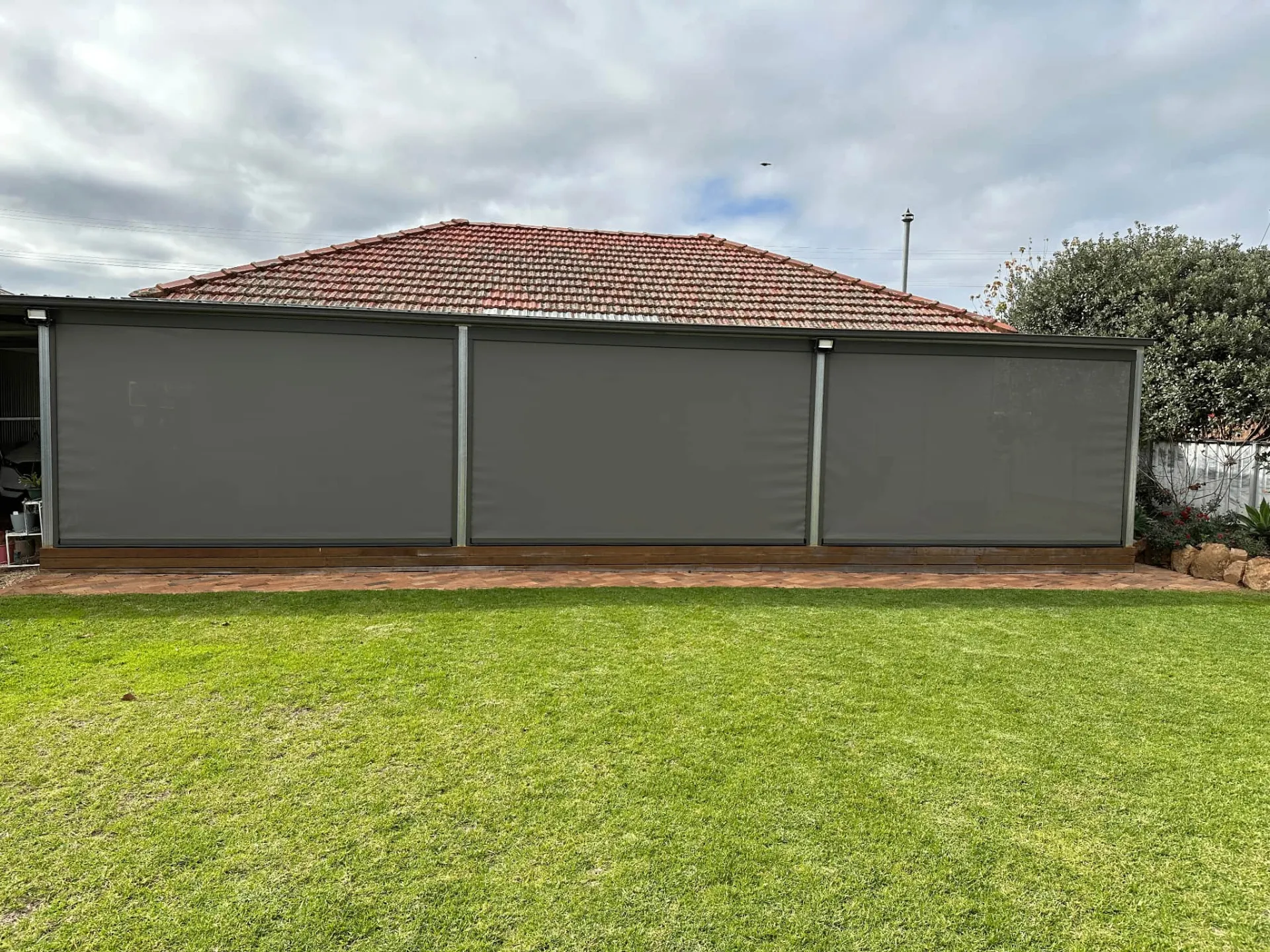 Complete patio enclosure with multiple grey blinds