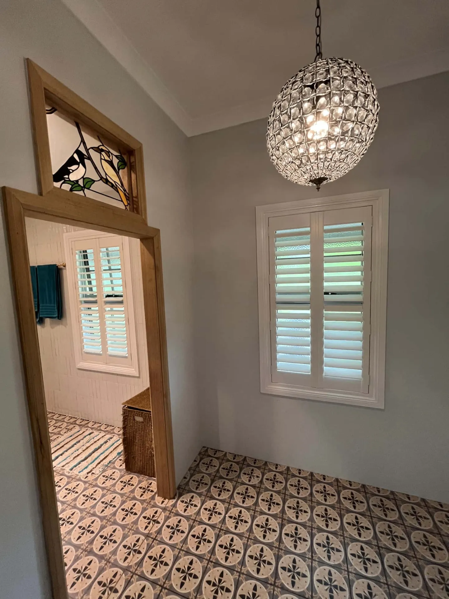 Plantation shutters in hallway with decorative tiled floor