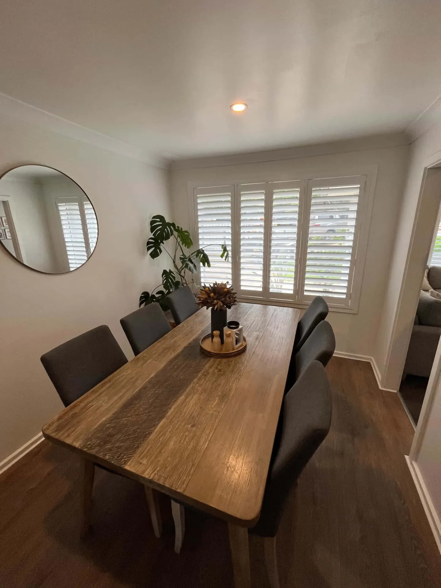 White shutters in dining room with rustic timber table