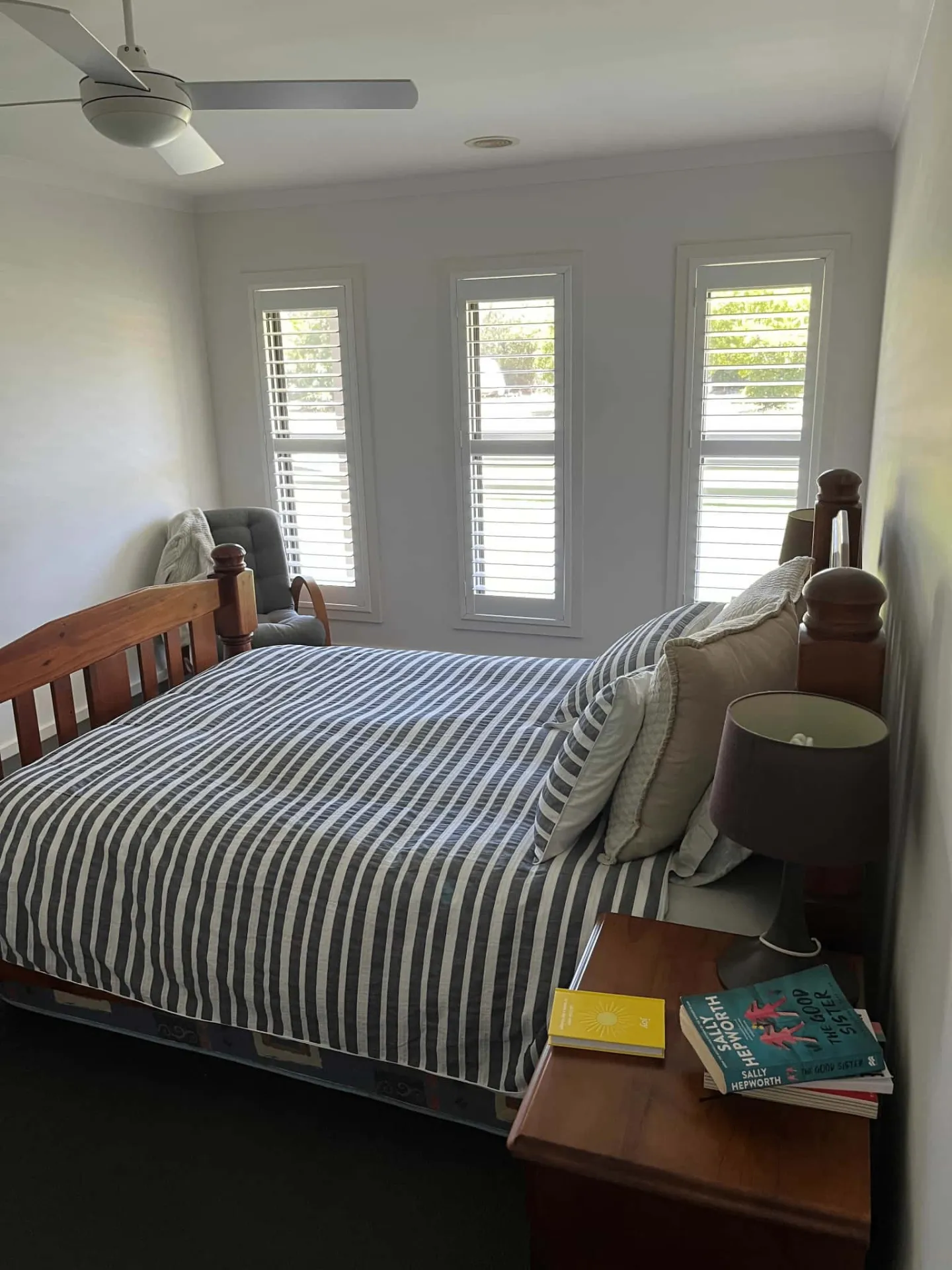 Triple window shutters in cozy bedroom setting