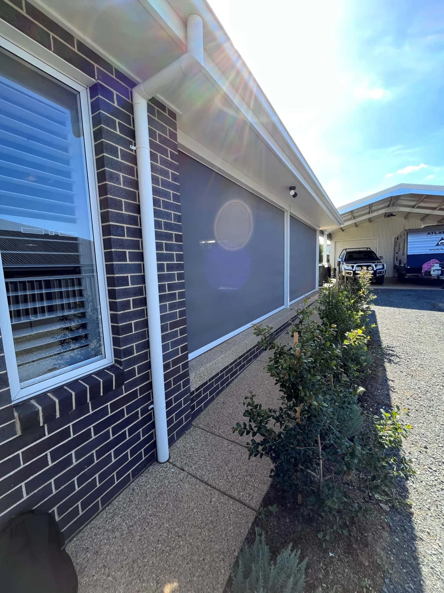 Zipscreens on dark brick home exterior providing sun protection